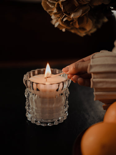 A close-up shot captures the moment someone lights the Arlow candle by Auden Lueur.