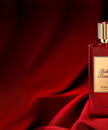 Scarlet Eau de Parfum by Bella Perversa, created by influencer Daisy Marquez, 2.5 fl oz, displayed alongside two of its key notes of bing cherries and jasmine flowers.