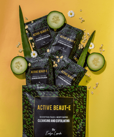 Cleansing and exfoliating wipes displayed with cucumbers, flowers and oats.